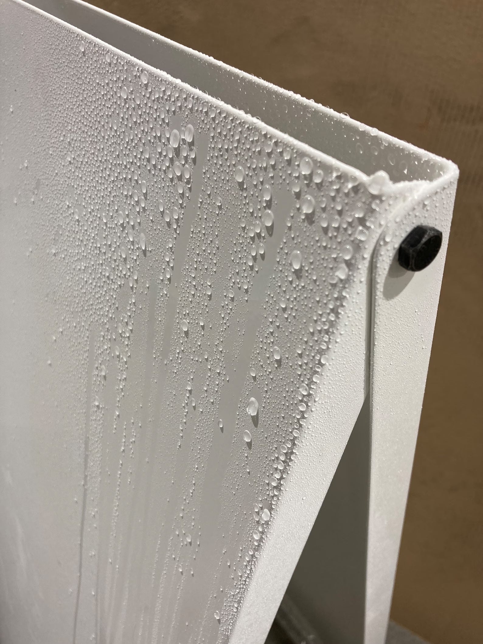 Weatherproof sandwich board sign made of white metal with water droplets